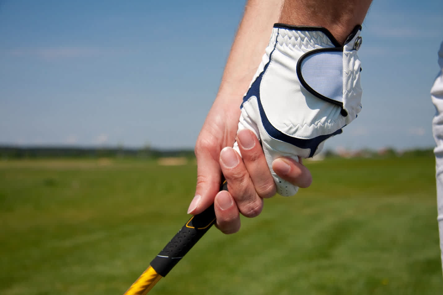 Proper golf grip technique demonstration emphasizing pinky pressure method for correct wrist hinge positioning